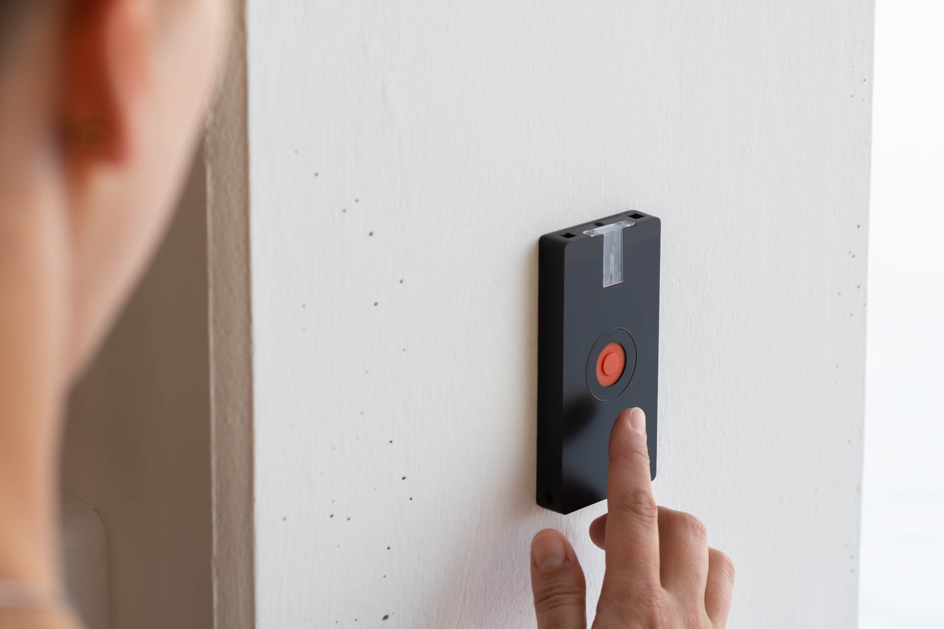 JA-156J Multifunktions-Funk-Paniktaster, schwarz, Wandmontage, rote Taste wird gedrückt